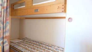 Een stapelbed met een houten hoofdbord en een matras met bloemenprint.