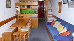 A compact living space with a kitchenette, a dining area with wooden furniture, and a sofa with colorful cushions. - Ski-in/ski-out & foot of the slopes, 2nd floor, view mountain, balcony, tv, 35m², Les Arcs (Les Arcs)