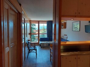 A narrow hallway leading to a room with a bed, a chair, and a window with a view of trees. - 11st floor, view valley, balcony, tv, 40m², Les Arcs (Les Arcs)