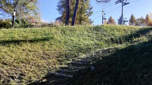 Une colline herbeuse avec un escalier en pierre qui mène au sommet.