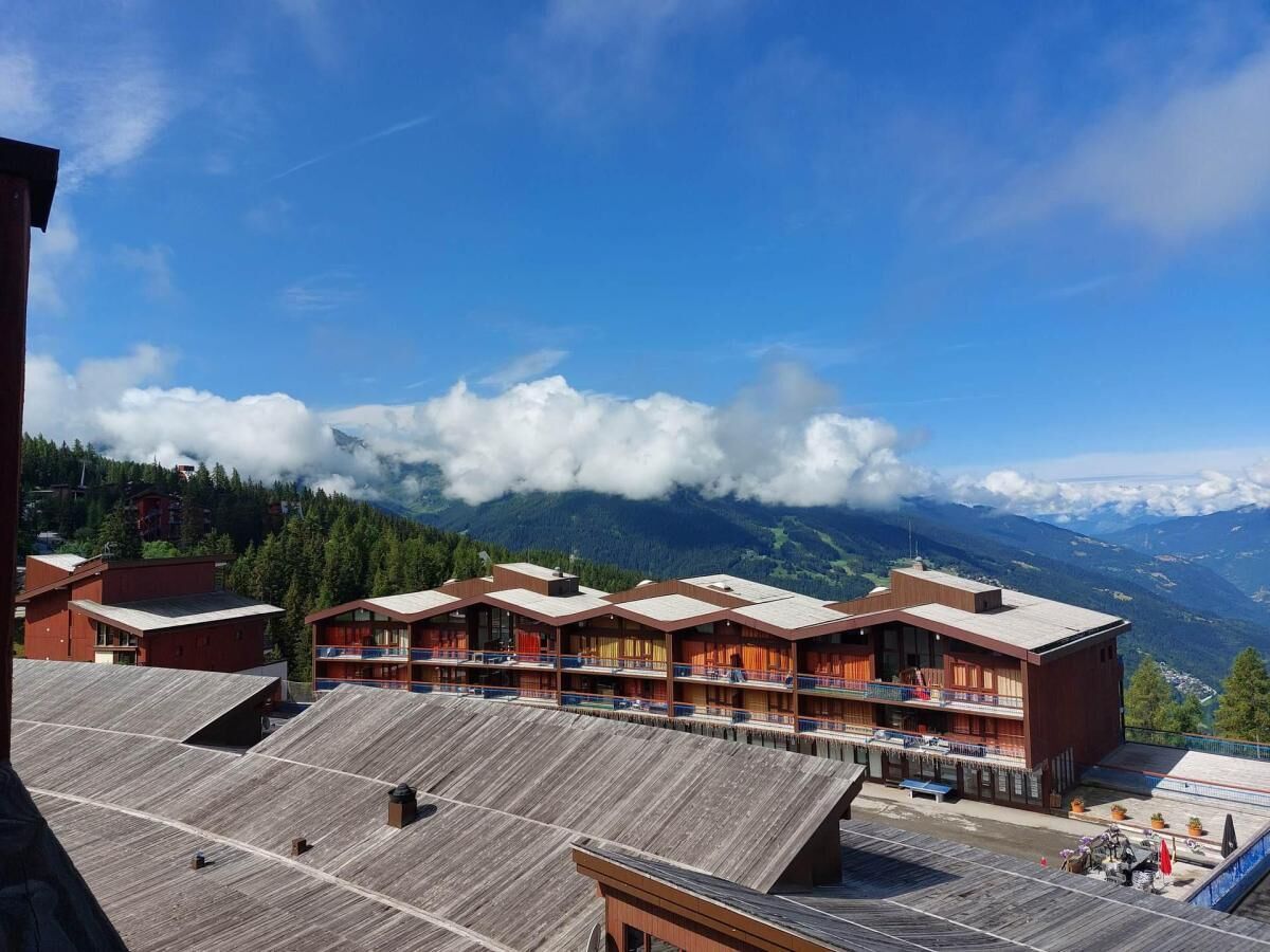 Un hôtel doté de nombreux balcons et offrant une vue sur la montagne.
