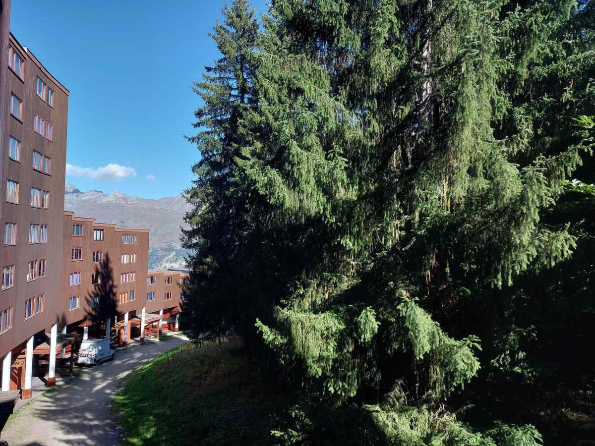 Ein mehrstöckiges Gebäude mit einem großen Baum davor.