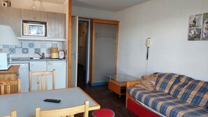 A compact living space with a kitchenette, a dining table, a sofa, and a glass-top table. - 100m from ski slopes, 2nd floor, view firs, swimming pool, balcony, tv, 30m², Les Arcs (Les Arcs)