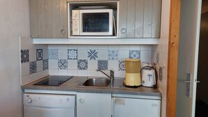 A compact kitchen with a microwave, toaster, and dishwasher. - 100m from ski slopes, 2nd floor, view firs, swimming pool, balcony, tv, 30m², Les Arcs (Les Arcs)