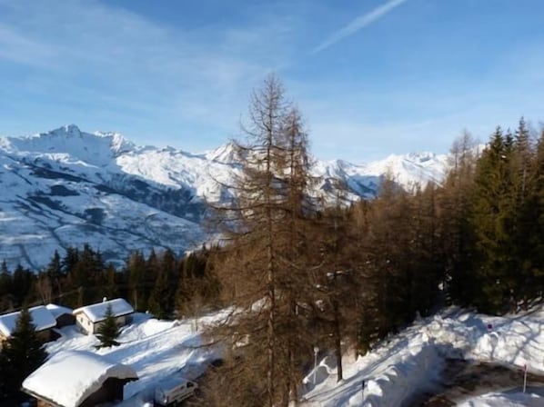 A mountainous landscape with snow-covered peaks and a clear sky.