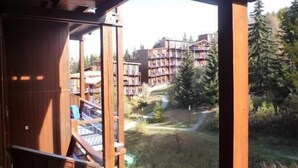 A wooden balcony with a view of a building complex and surrounding trees. - Ski-in/ski-out & foot of the slopes, 3rd floor, balcony, tv, 40m², Les Arcs (Les Arcs)