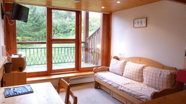 A cozy cabin with a wooden interior, a sofa, a table, and a TV mounted on the wall. - Ski-in/ski-out & foot of the slopes, 3rd floor, balcony, tv, 40m², Les Arcs (Les Arcs)