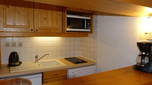 A kitchen with wooden cabinets, a microwave, a coffee maker, and a dishwasher. - Ski-in/ski-out & foot of the slopes, 3rd floor, balcony, tv, 40m², Les Arcs (Les Arcs)