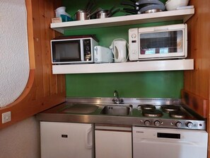 A compact kitchen with a microwave, toaster, kettle, and a stove. - 13rd floor, view valley, balcony, tv, 35m², Les Arcs (Les Arcs)