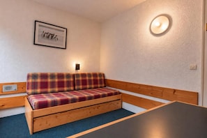 A room with a plaid sofa, a small table, a wall-mounted light, and a framed picture. - 4th floor, view firs, tv, 13m², Les Arcs (Les Arcs)