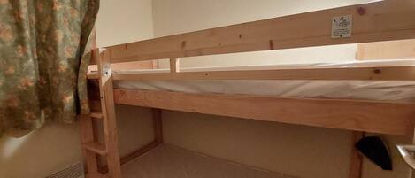 A bunk bed with a wooden frame and a ladder.