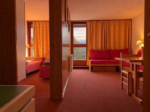 A room with a bed, a sofa, a table, and a view through a window. - 10th floor, view valley, balcony, tv, 40m², Les Arcs (Les Arcs)
