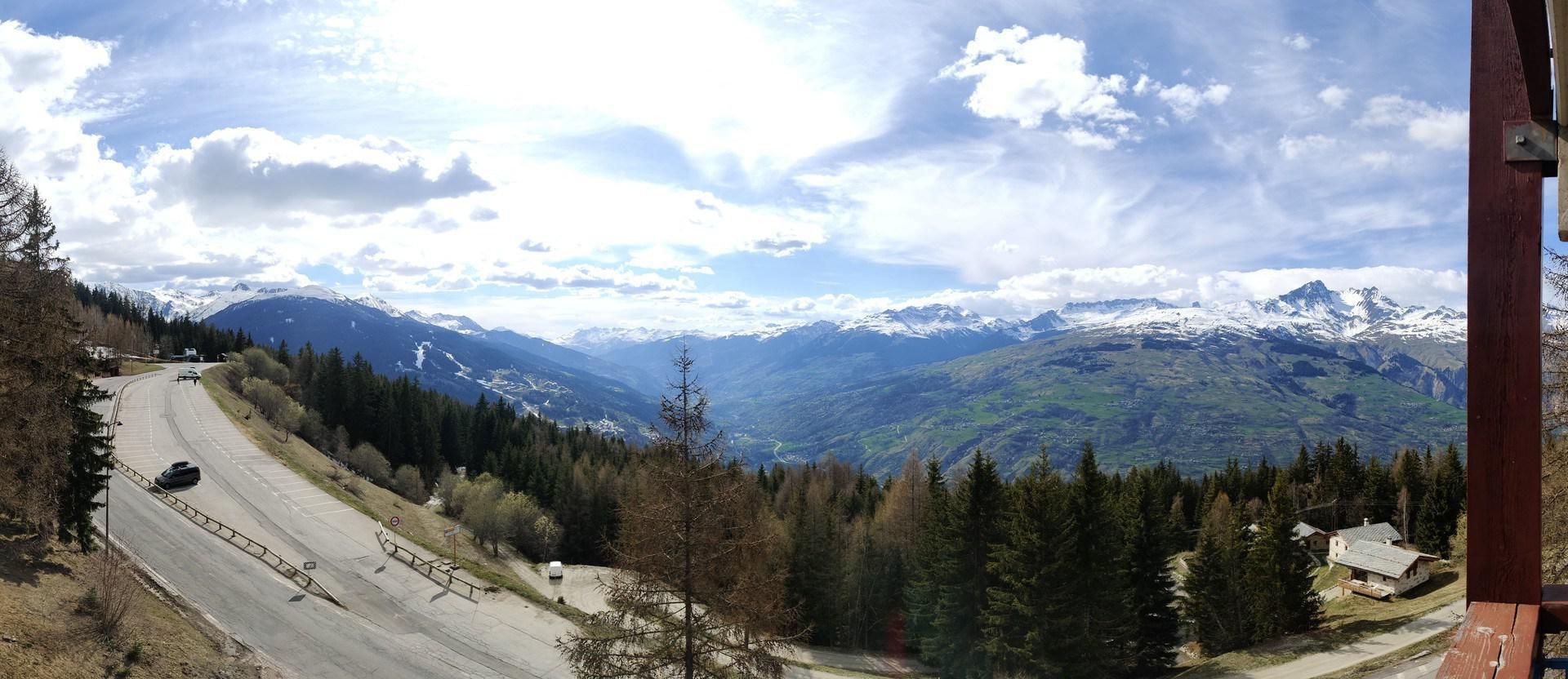 Una carretera de montaña con vistas a picos nevados y bosques densos.