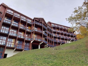 Ett hotell med flera våningar, balkonger och ett sluttande tak.