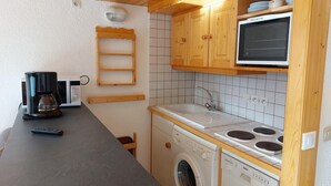A compact kitchen with a washing machine, a microwave, and a sink. - 300m from ski slopes, 4th floor, view valley, tv, 65m², Les Arcs (Les Arcs)