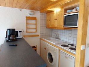 A compact kitchen with a washing machine, a microwave, and a sink. - 300m from ski slopes, 4th floor, view valley, tv, 65m², Les Arcs (Les Arcs)