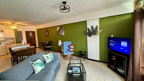 Un salon avec un canapé, une table basse et un téléviseur.