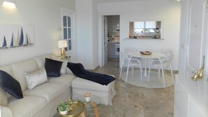 Ein Wohnzimmer mit einer Couch, einem Couchtisch und einem Essbereich mit Stühlen und einem Tisch.