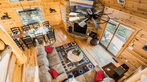 A spacious wooden cabin with a dining area, a fireplace, and a large TV. - Pet Friendly Cabin|Hot Tub|Pool Table|Outdoor Fireplace (Blue Ridge)