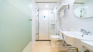 Ein modernes Badezimmer mit Duschkabine aus Glas, Toilette, Waschbecken und Spiegel.