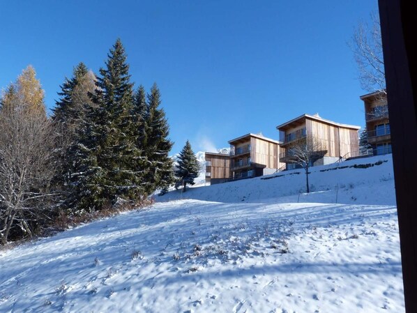A snow-covered landscape with buildings and trees.