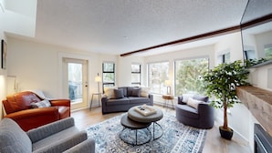 A modern living room with a grey sofa set, a brown leather chair, and a blue patterned rug. - Greyhawk by Whistler Premier (Whistler)