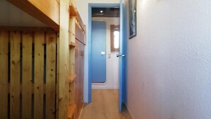 A narrow hallway with wooden paneling on one side and a blue door at the end. - 50m from shops, 3rd floor, view resort, balcony, tv, 33m², Les Arcs (Les Arcs)