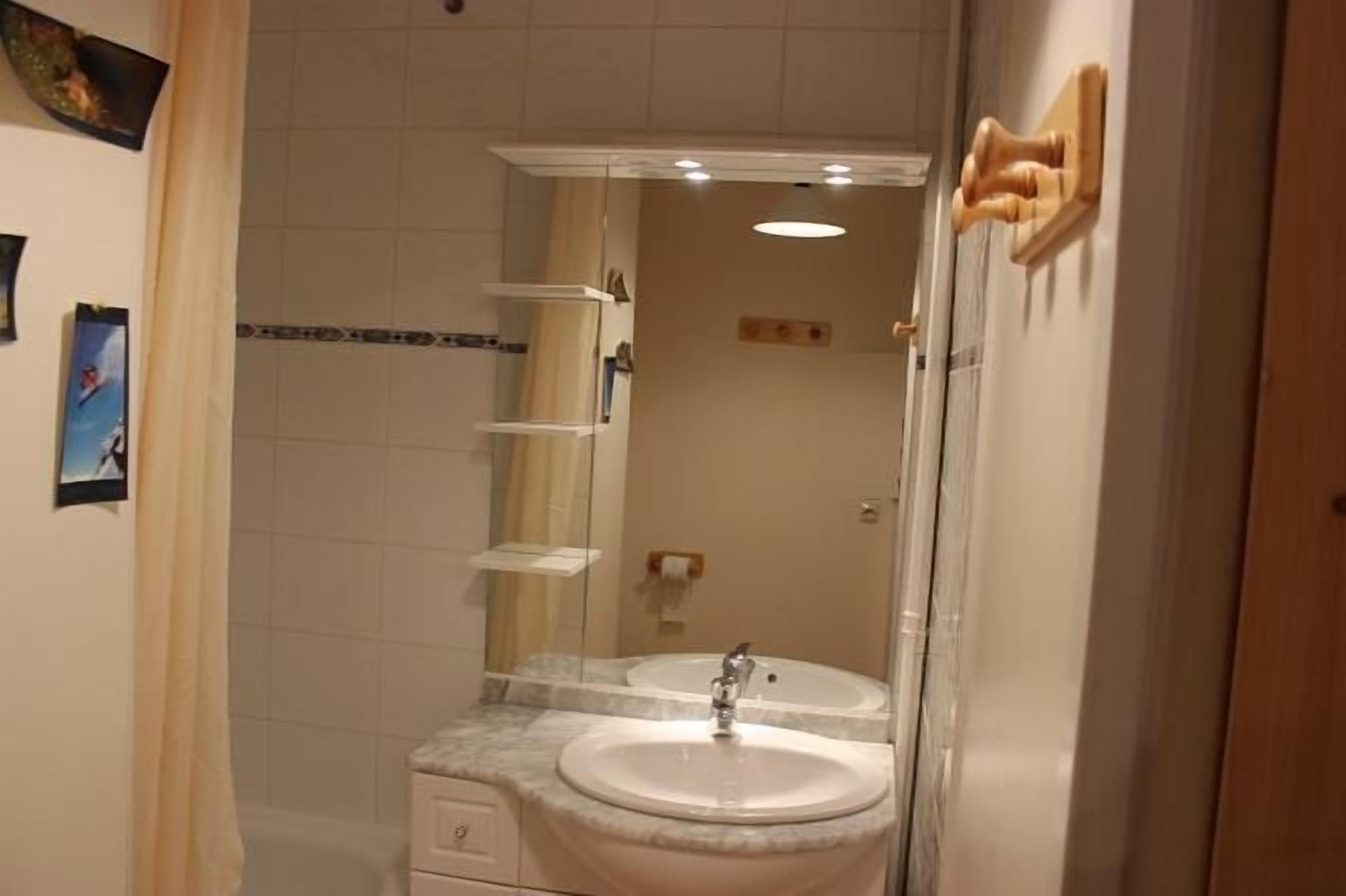 A bathroom with a double sink, a mirror, and a shower area.
