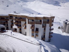 A multi-story hotel with balconies, set against a snowy mountain backdrop. - 100m from resort center, 3rd floor, balcony, tv, 48m², Val Thorens (Val Thorens)