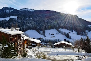 A snow-covered mountain landscape with wooden cabins and a ski resort. - Ground floor, tv, 21m², Le Grand Bornand (Le Grand-Bornand)
