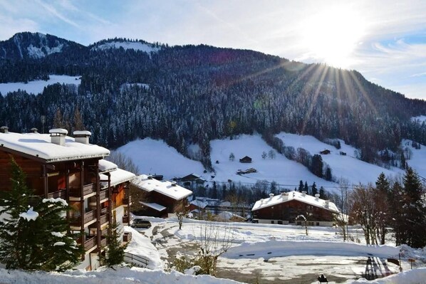A snow-covered mountain landscape with wooden cabins and a ski resort. - Ground floor, tv, 21m², Le Grand Bornand (Le Grand-Bornand)