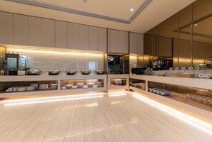 Una cuina moderna amb electrodomèstics integrats, una illa central i una finestra gran.