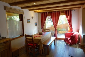 Enjoy meals in this charming dining area with a wooden table for two, a bench, and a view of the surrounding greenery.