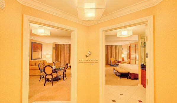 Een hotelkamer met een eethoek, een bed en een badkamer.