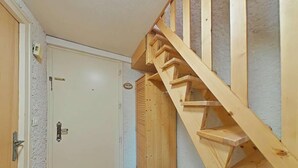 A wooden staircase leading to a door with a textured wall and a wooden floor. - 3rd floor, balcony, fireplace or stove, tv, 63m², Le Grand Bornand (Le Grand-Bornand)