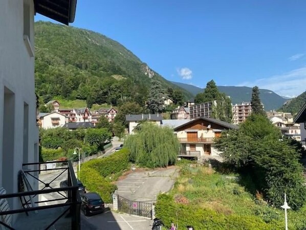 Zona residencial con casas, un estacionamiento y montañas al fondo.