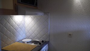 A compact kitchen with a microwave, a stove, and a sink.