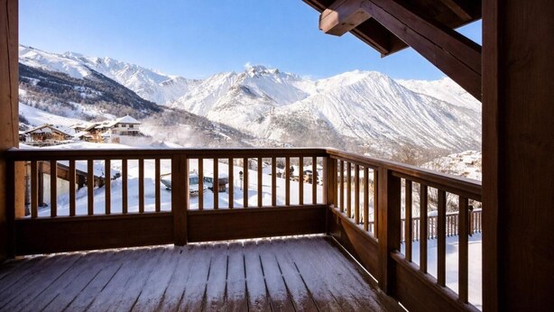 A wooden balcony with a view of snow-covered mountains and a small village below. - 100m from ski slopes, 3rd floor, balcony, parking, tv, 68m², Saint Martin de Belleville (Saint-Martin-de-Belleville)