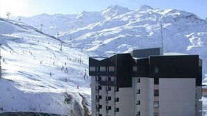 Un bâtiment moderne avec une piste de ski en arrière-plan.