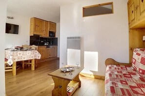 A compact living space with a kitchenette, a dining area, and a sofa. - 150m from resort center, 6th floor, view mountain/ski slopes, tv, 28m², Les Menuires (Les Menuires)