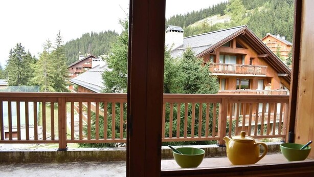 A wooden balcony with a view of a mountainous area, including houses and trees. - 20m from ski slopes, 1st floor, swimming pool, balcony, tv, ski locker, 24m², Méribel (Méribel - Les Allues)