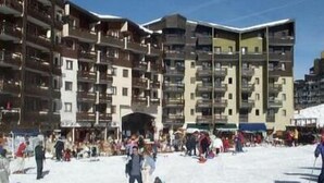 A multi-story building with balconies, likely a hotel or apartment complex.