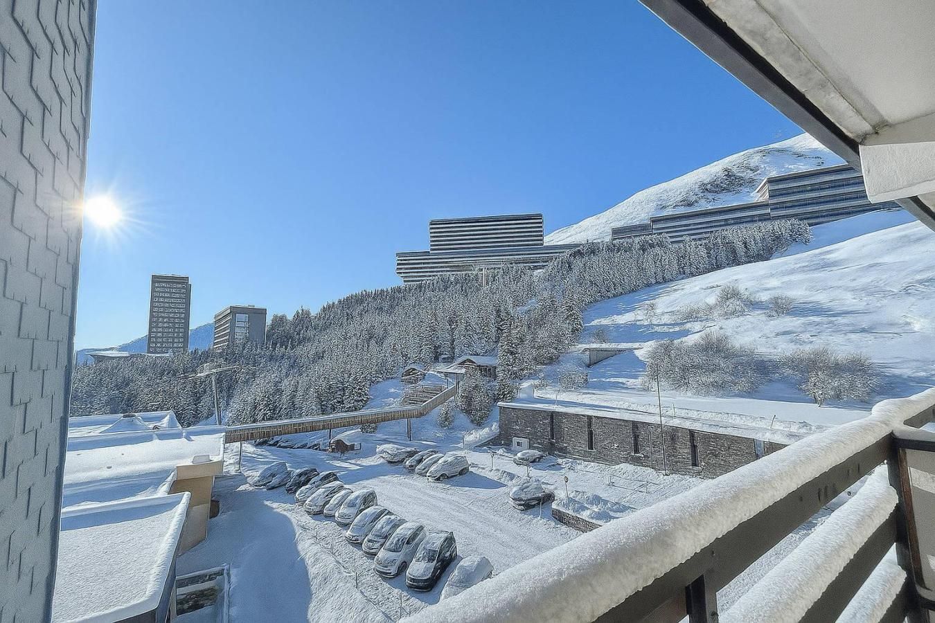 Paisatge nevós amb aparcament, edificis i cel serè.