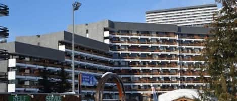 A multi-story hotel with balconies, a self-service area, and a ski lift area.