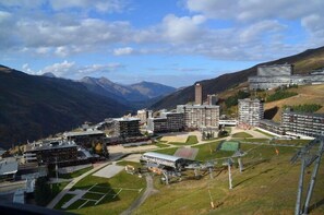 Un complexe hôtelier comprenant plusieurs bâtiments, une cour centrale et des montagnes environnantes.