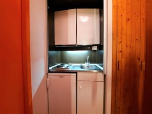A compact kitchenette with a stove, sink, and cabinets. - 10m from ski slopes, 4th floor, balcony, tv, 17m², Les Menuires (Les Menuires)