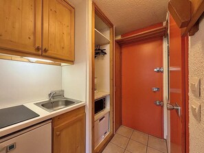 A compact kitchen with wooden cabinets, a sink, and a microwave. - 10m from ski slopes, 8th floor, balcony, tv, 18m², Les Menuires (Les Menuires)