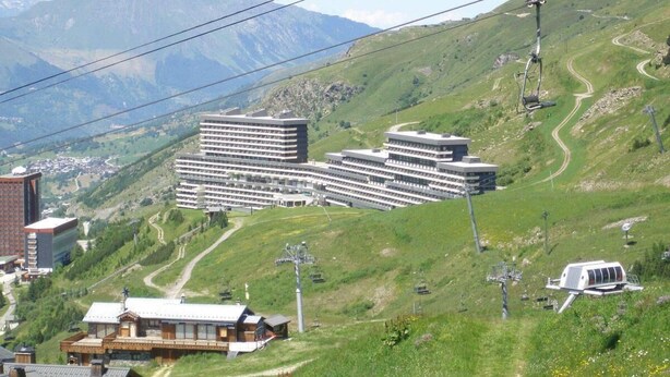 A hotel with multiple buildings, a ski lift, and a mountainous backdrop. - 150m from shops, 7th floor, tv, ski locker, 13m², Les Menuires (Les Menuires)