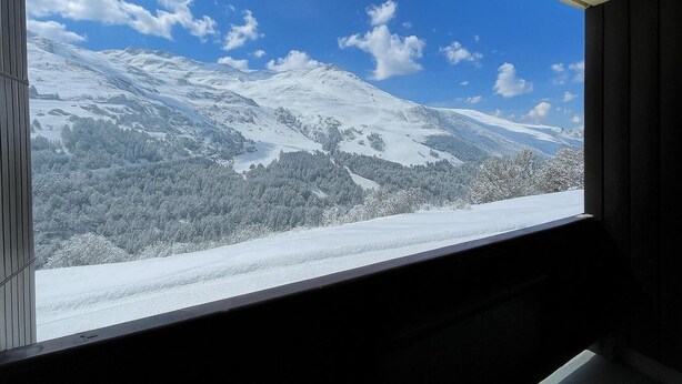 A window view of a snow-covered mountain landscape with a clear sky. - 10m from ski slopes, Ground floor, balcony, tv, ski locker, 31m², Les Menuires (Les Menuires)