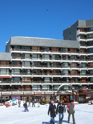A multi-story hotel with a modern architectural design, featuring balconies and large windows.
